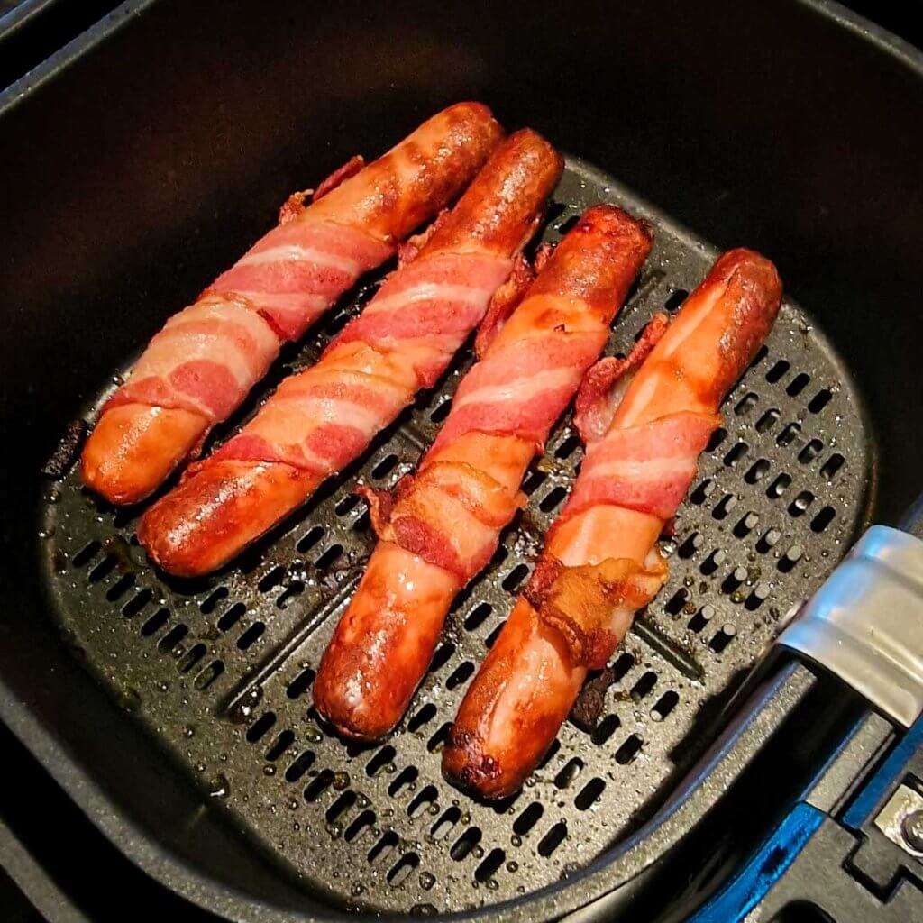 air fried bacon wrapped hot dogs ready in the air fryer basket