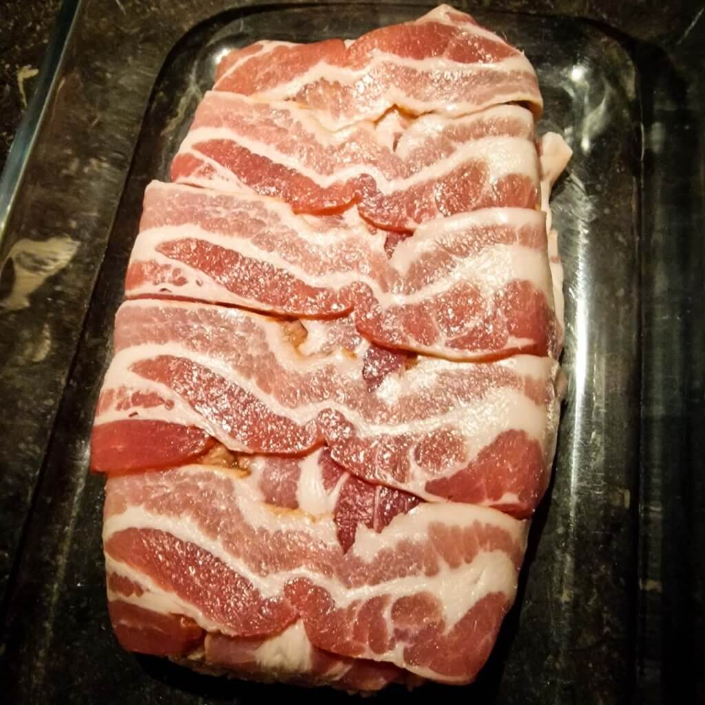 Raw bacon-wrapped meatloaf.